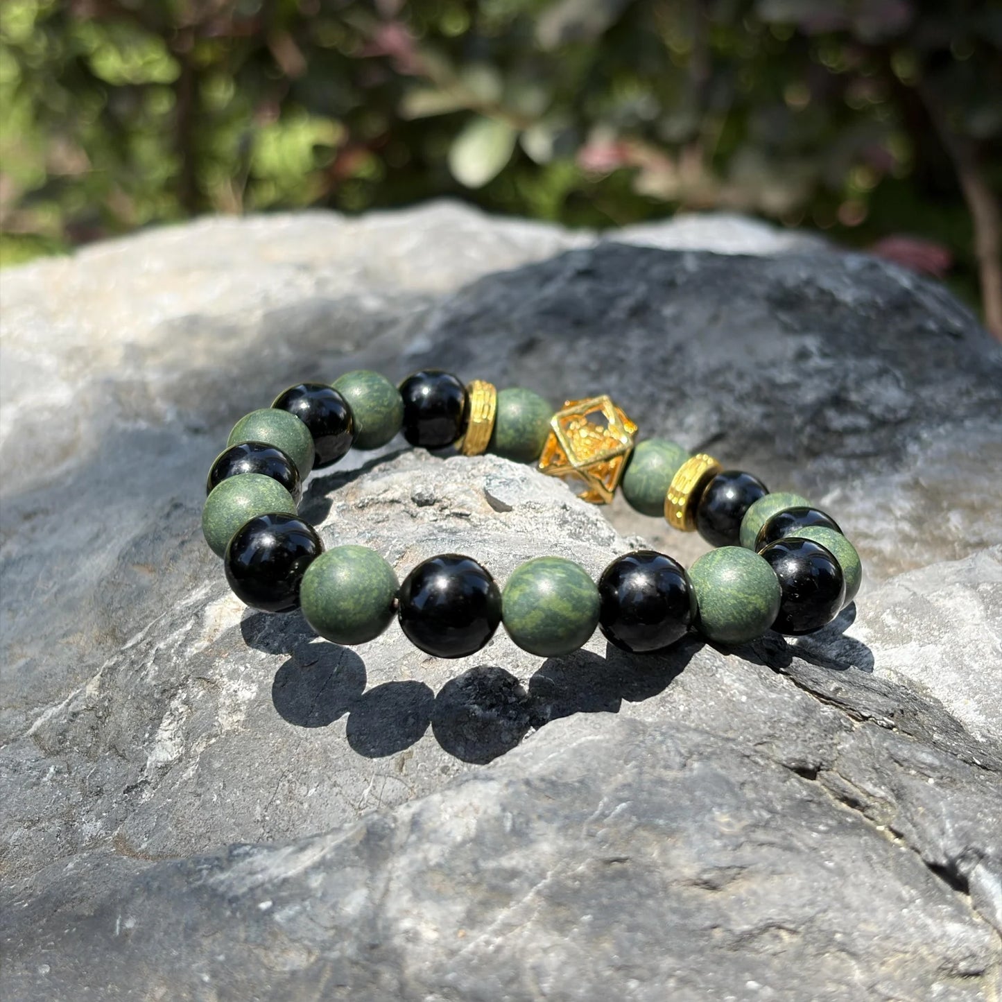 AZURE DRAGON Guardian Formula bracelet placed on natural stone to show its green and black bead contrast.