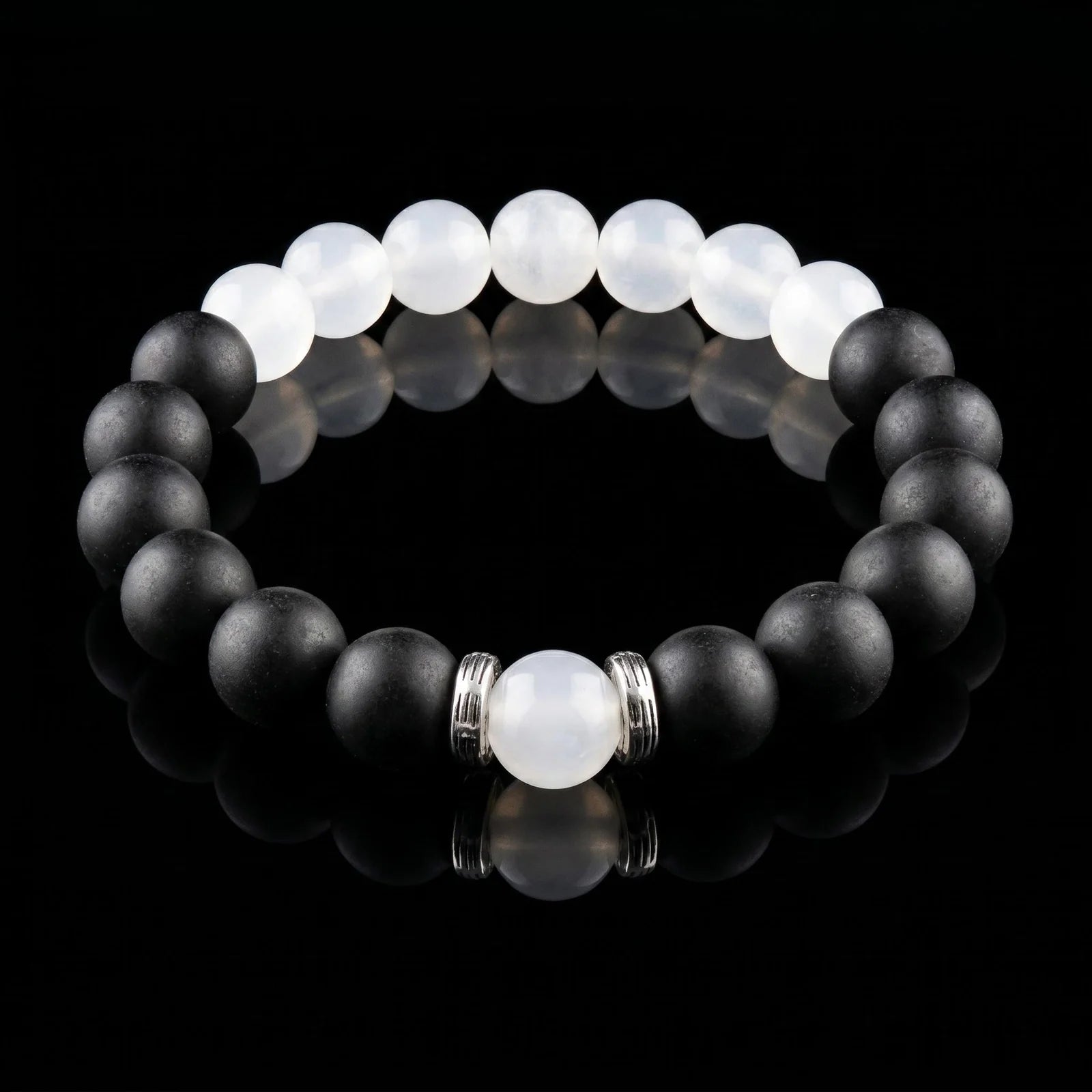 SKIN BREATH Still Mind wearable incense bracelet with black and white beads on a black reflective surface.