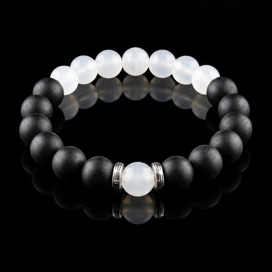 SKIN BREATH Still Mind wearable incense bracelet with black and white beads on a black reflective surface.