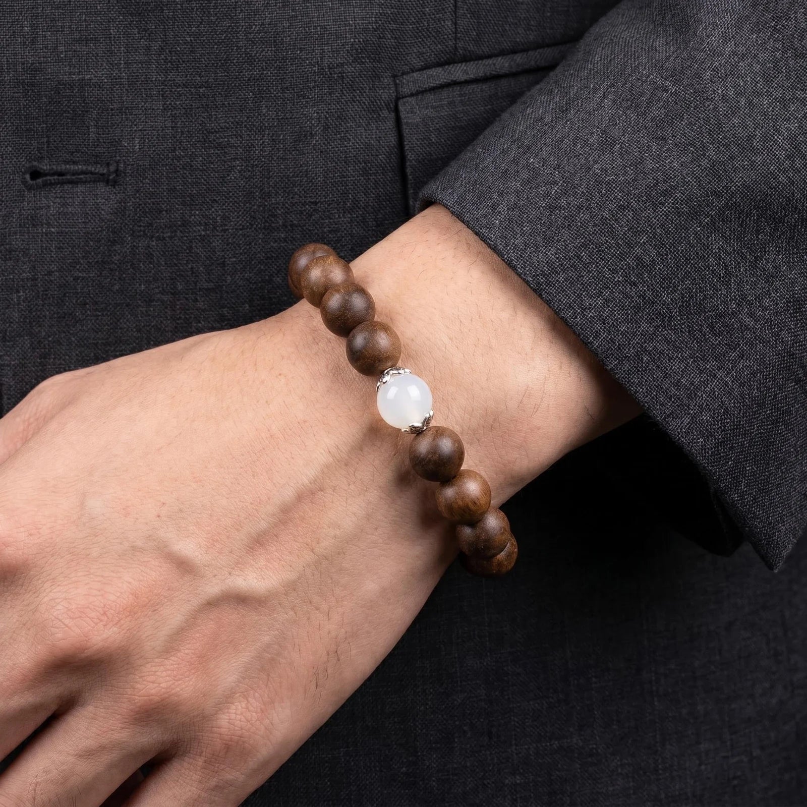 STILL MOON wearable incense bracelet worn with a dark suit sleeve for a quiet refined men's styling.