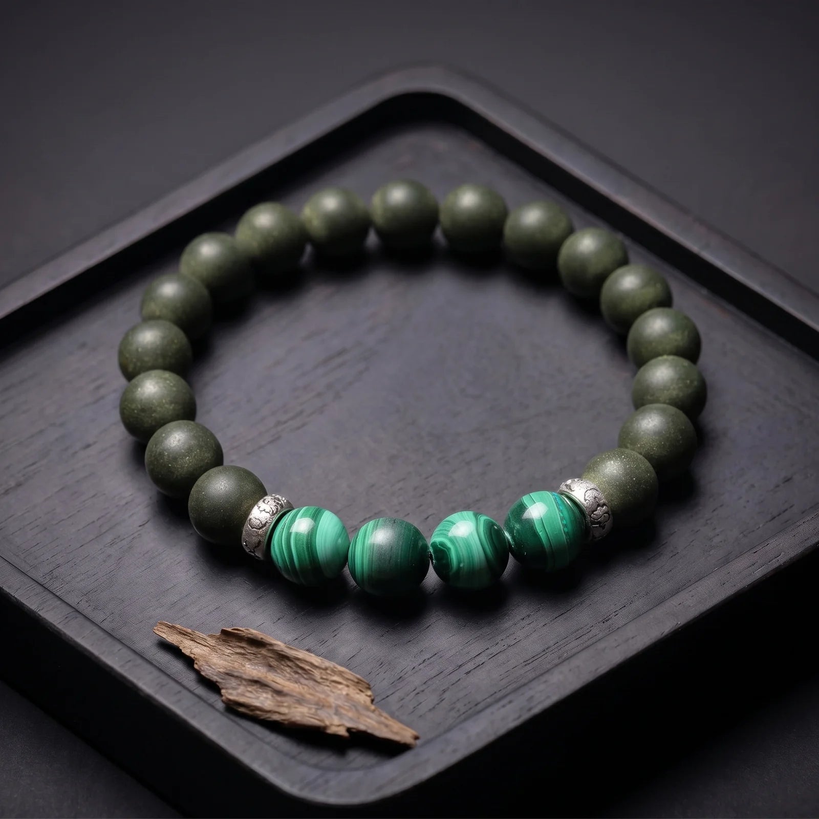 EAST PAVILION wearable incense bracelet placed on a dark tray with agarwood material.