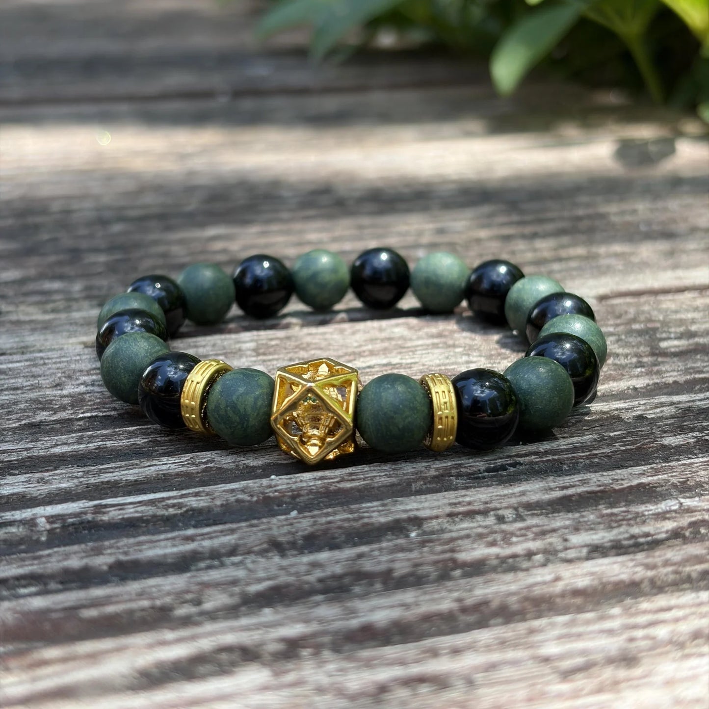 AZURE DRAGON green and black aromatic bead bracelet placed on weathered wood with natural light.