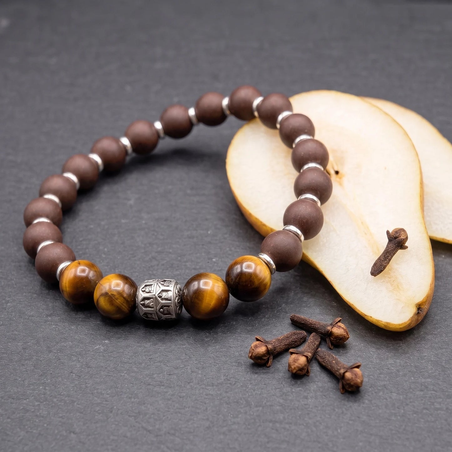 PEAR BLOSSOM bracelet flat lay with pear slices and cloves to show its soft aromatic character.