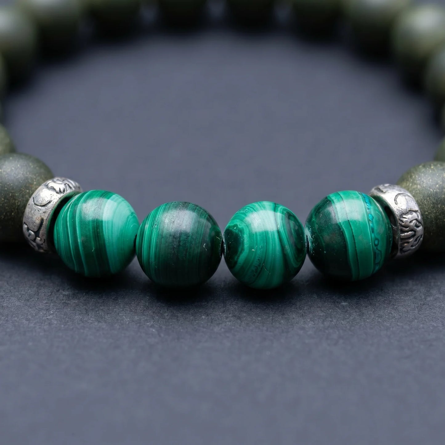 EAST PAVILION bracelet close-up showing green malachite-style beads and silver-toned spacer details.