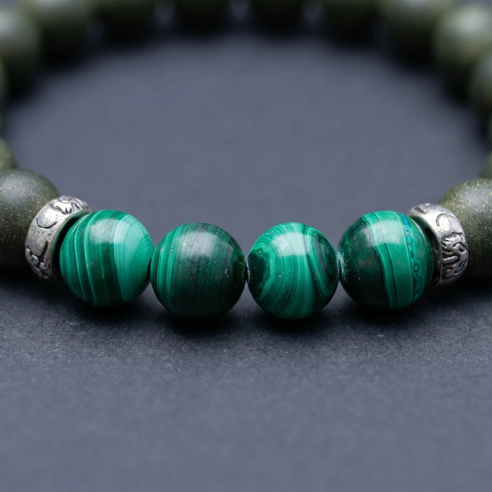 EAST PAVILION bracelet close-up showing green malachite-style beads and silver-toned spacer details.