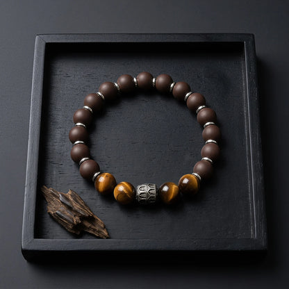 PEAR BLOSSOM wearable incense bracelet placed in a dark tray with wood material.