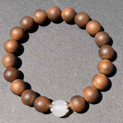 STILL MOON wearable incense bracelet shown from above with brown beads and a white center bead.