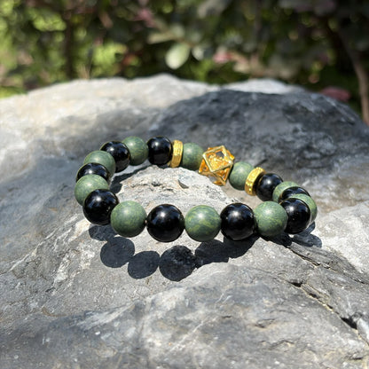 AZURE DRAGON Guardian Formula bracelet placed on natural stone to show its green and black bead contrast.