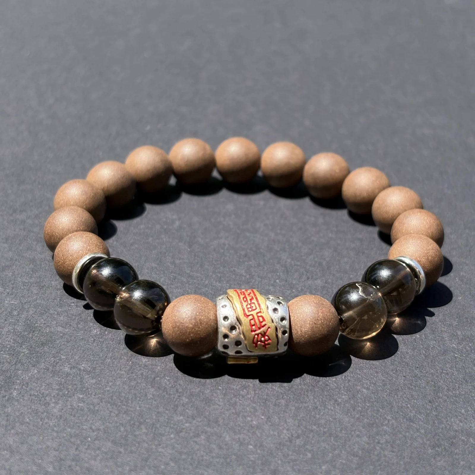 WARM YANG aromatic bead bracelet shown from an angled view on a clean gray surface.