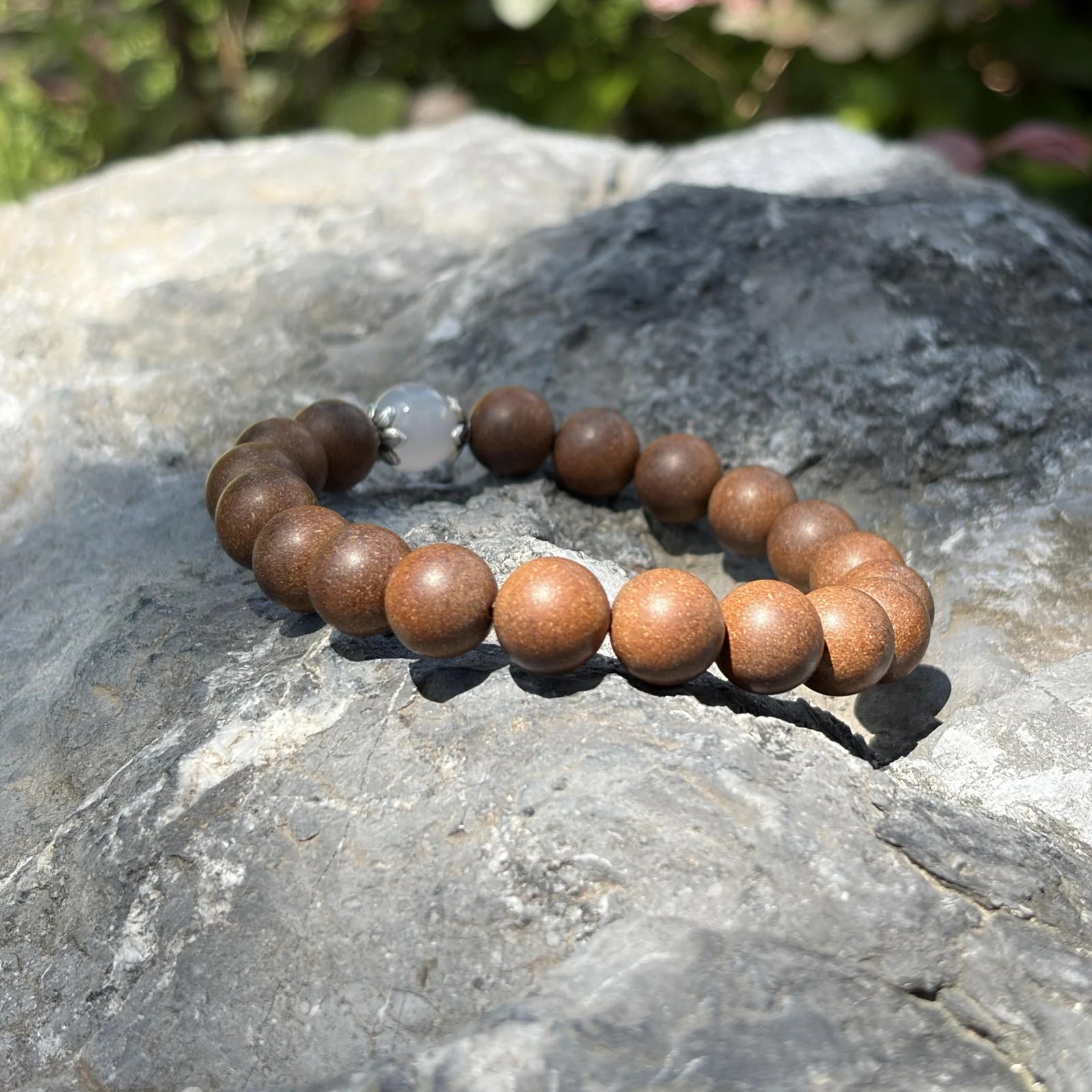 STILL MOON aromatic bead bracelet placed on natural stone in soft outdoor light.