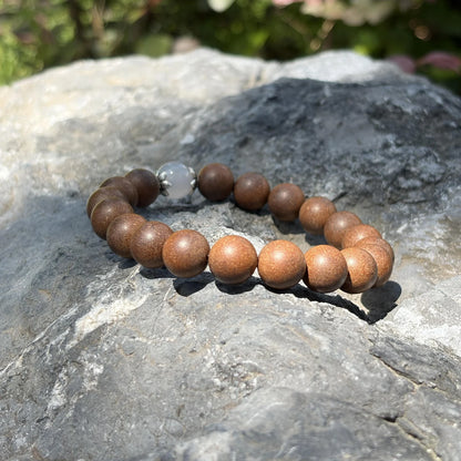 STILL MOON aromatic bead bracelet placed on natural stone in soft outdoor light.