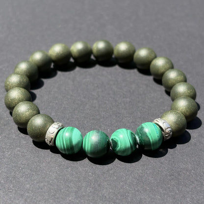 EAST PAVILION green aromatic bead bracelet shown from an angled view on a dark surface.