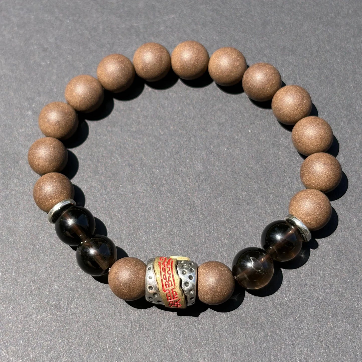WARM YANG wearable incense bracelet shown from above with brown beads and dark accent beads.