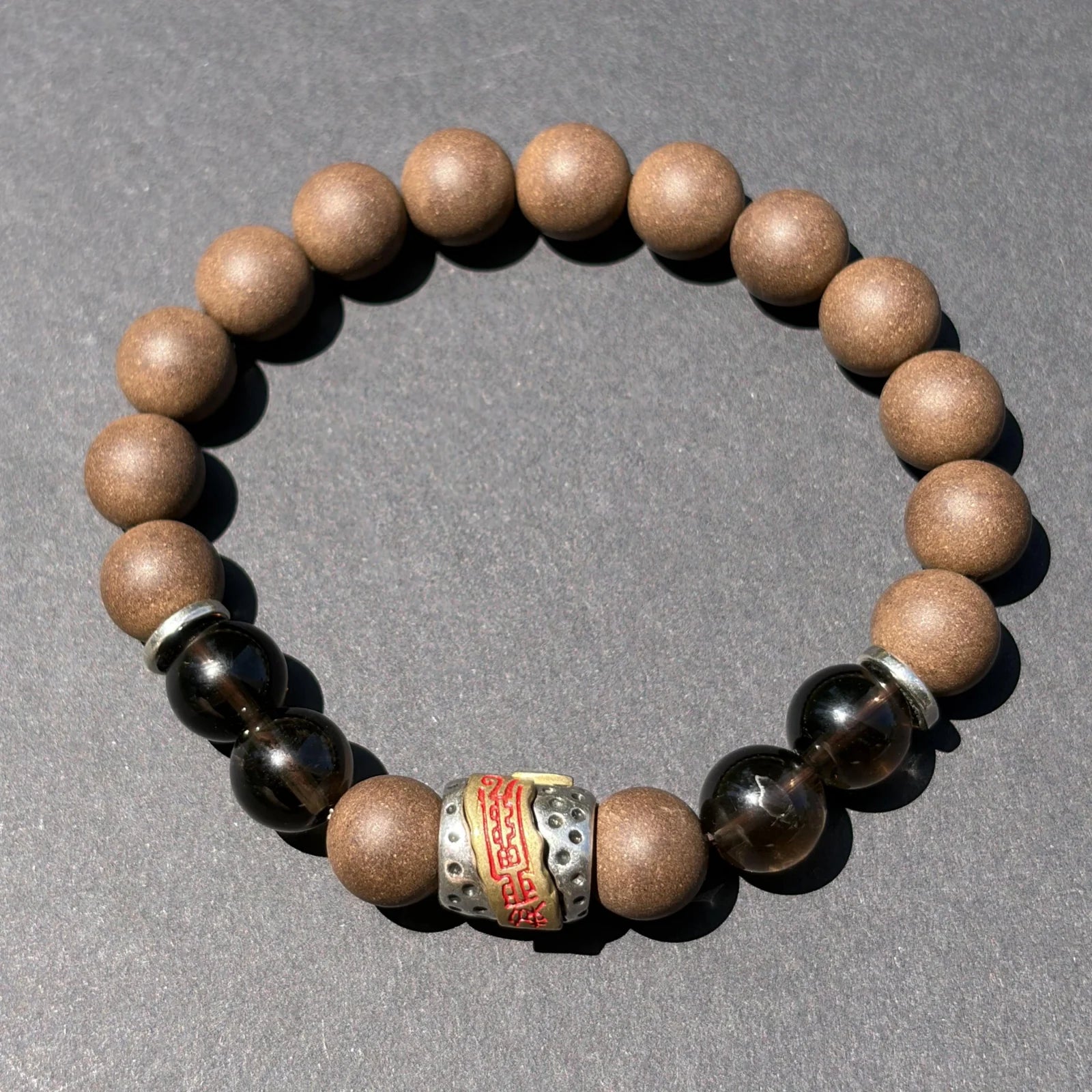 WARM YANG wearable incense bracelet shown from above with brown beads and dark accent beads.