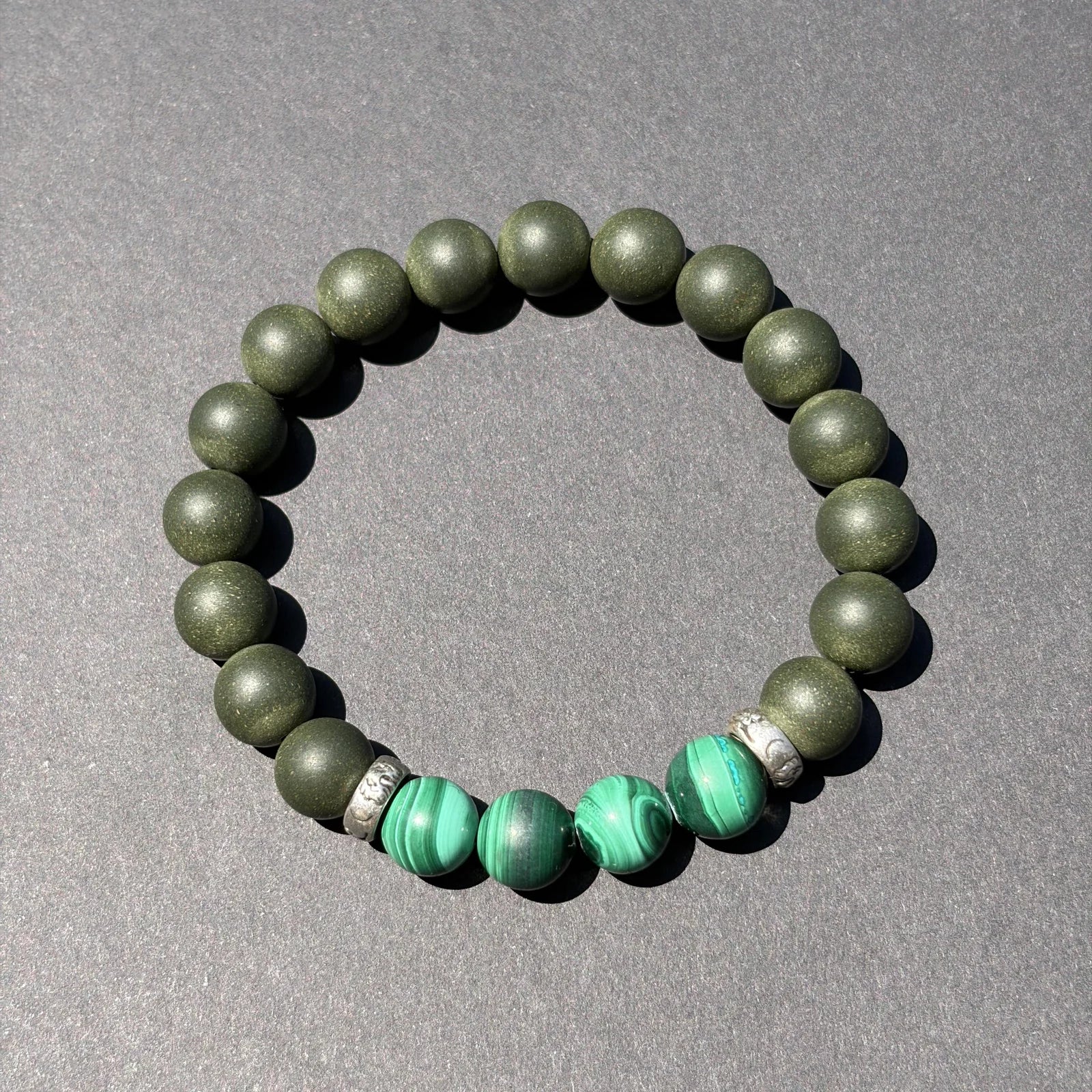 EAST PAVILION wearable incense bracelet shown from above with green accent beads.