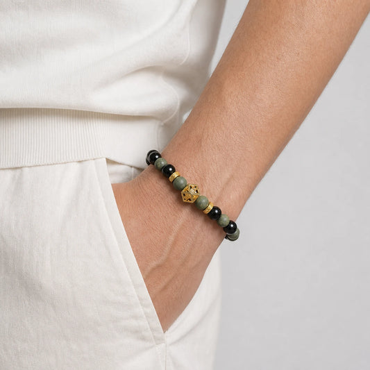 CENSEROOT Azure Dragon wearable solid incense bracelet worn with a cream knit top and trousers, showing blue-green aromatic beads, dark accents, and a Guge-inspired gold spacer.