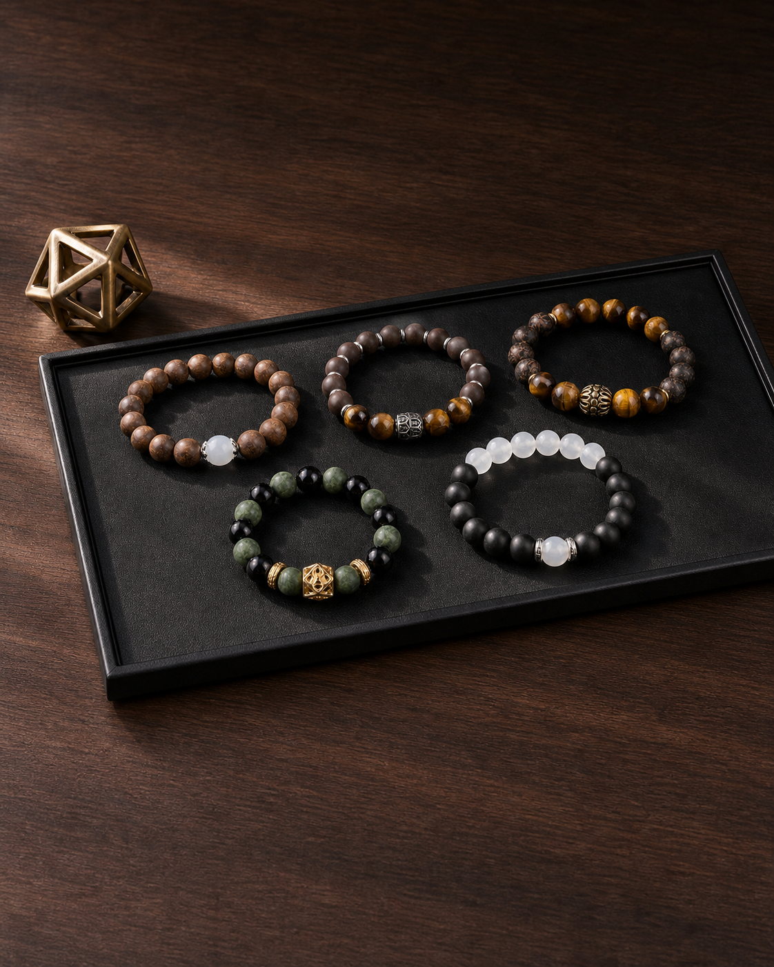Five CENSEROOT wearable incense bracelets arranged on a black presentation tray over dark walnut
